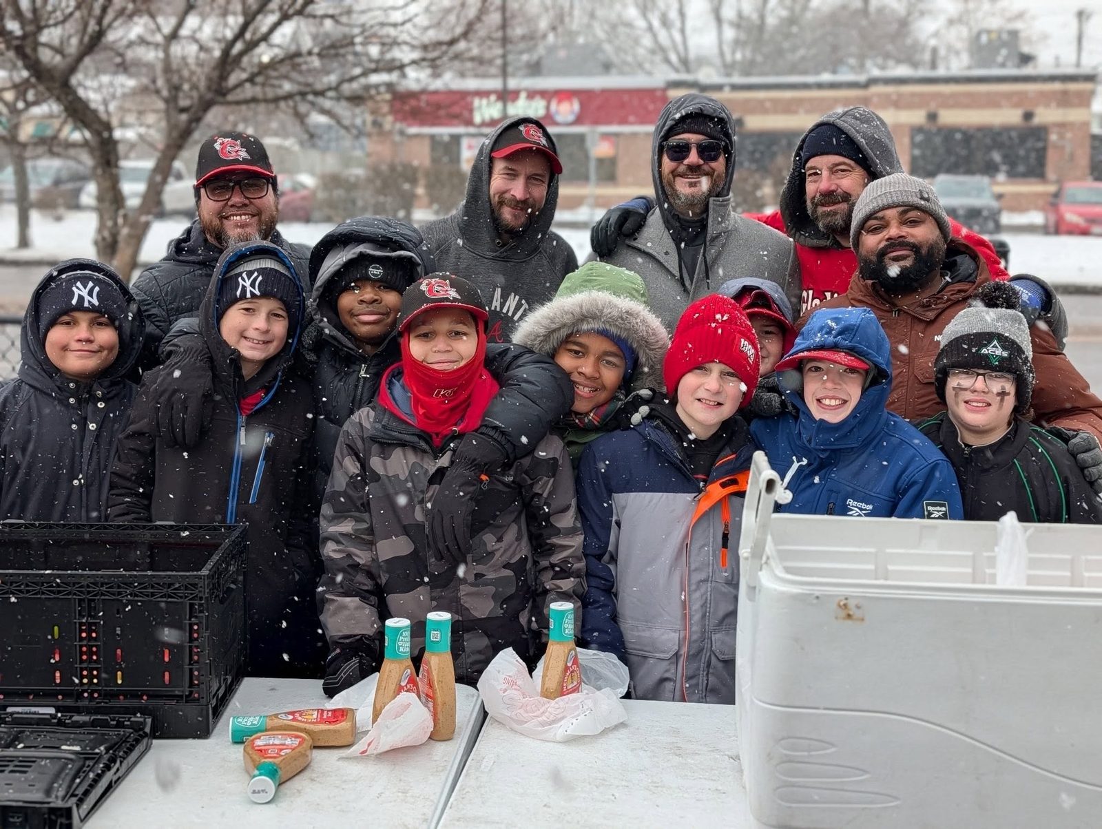 Team and families together on a snowy day